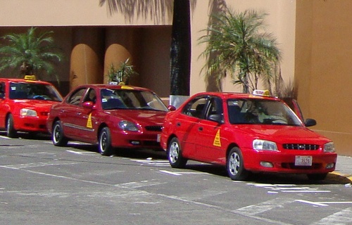 En todo Costa Rica, el gobierno licencia los taxis rojos oficiales con un triángulo amarillo