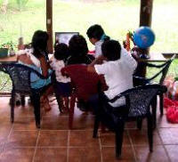 Maria, Khrys, Irene, Carmelita, and Willi use computers on the porch at The Bridge